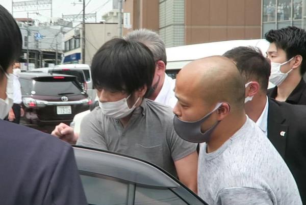 Tetsuya Yamagami (center) is apprehended by officers after allegedly shooting former Prime Minister Shinzo Abe in the city of Nara last July. | KYODO