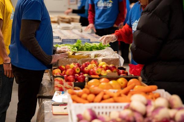 Volunteers organize do<em></em>nated food aid for students at a distribution point in Paris on Thursday. | BLOOMBERG